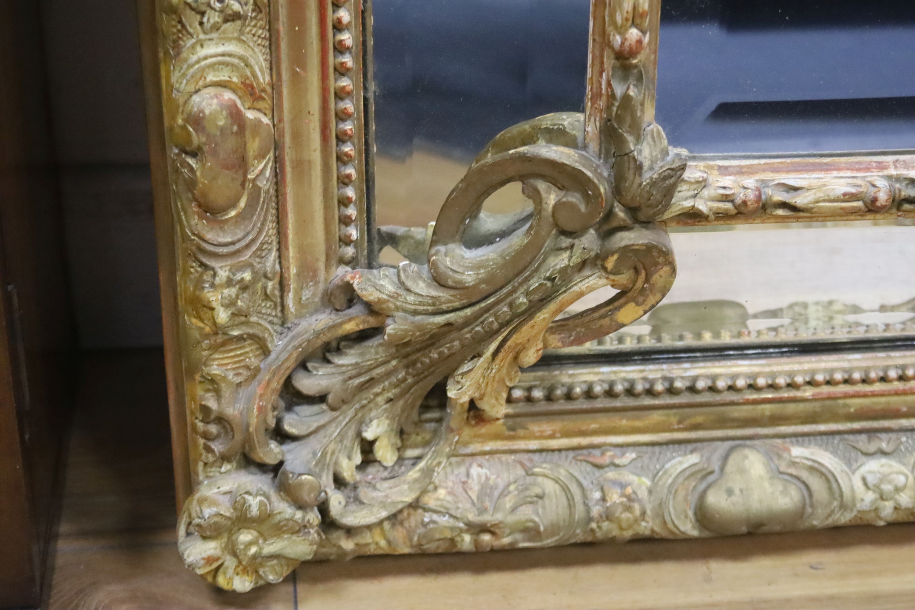 A large 19th century French gilt and gesso frame, bevel edged mirror with cushion margin, plated and C scroll, width 108cm, height 137cm